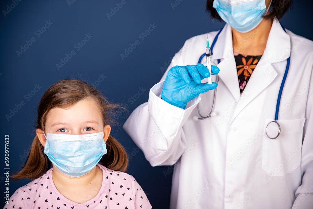 Vaccination concept. Feale doctor vaccinating cute little girl in clinic.