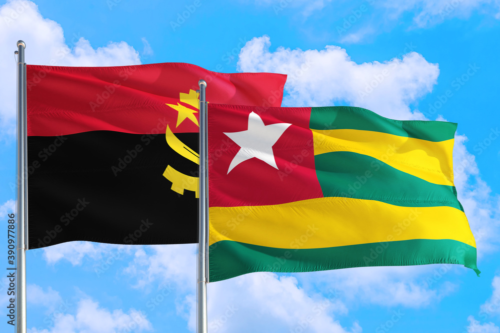 Togo and Angola national flag waving in the windy deep blue sky. Diplomacy  and international relations concept. Stock Photo