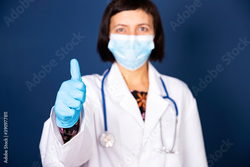 Woman doctor wearing protective mask outdoor showing OK sign.