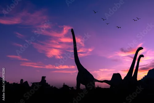 Fototapeta na wymiar silhouette dinosaur in the park and pink color sky backgrounds