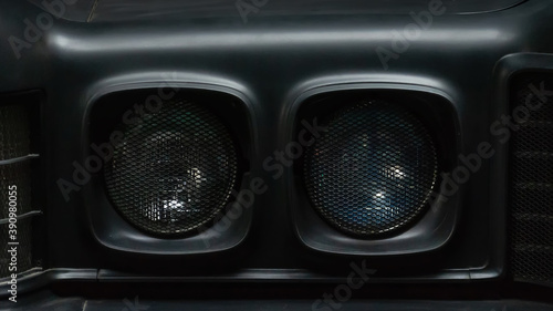 Headlights of a black old retro car. Close-up. Details.