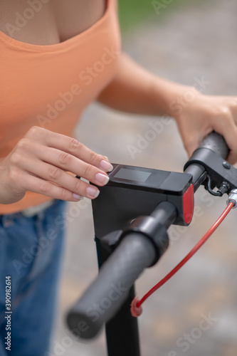 Close up picture of womans hand pressing buttins on a handlebar
