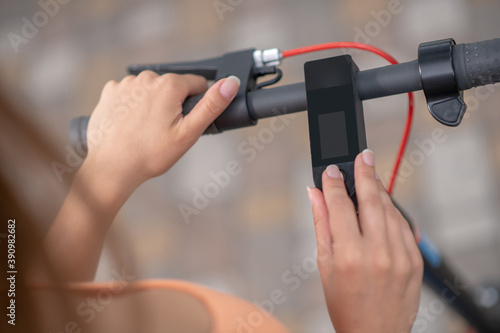 Close up picture of a hand pressing buttins on a handlebar