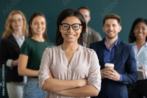 Multiethnic crew. Young biracial female confident qualified specialist hr ceo leader head member of diverse corporate team posing for portrait holding arms crossed on chest smiling looking at camera photo
