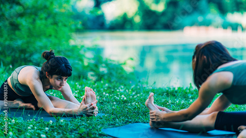 Mindfulness and Meditation. Women Doing Yoga by the Lake © Microgen