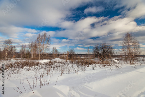 Winter landscape with snow, trees and sky with clouds