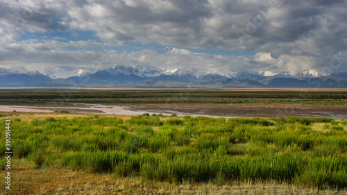 Colorful landscape view of Lenin Peak aka Ibn Sina peak in the snow-capped Trans-Alay or Trans-Alai mountain range in southern Kyrgyzstan with Kyzyl Suu river