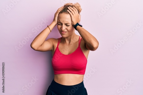 Beautiful caucasian woman wearing sportswear suffering from headache desperate and stressed because pain and migraine. hands on head. © Krakenimages.com