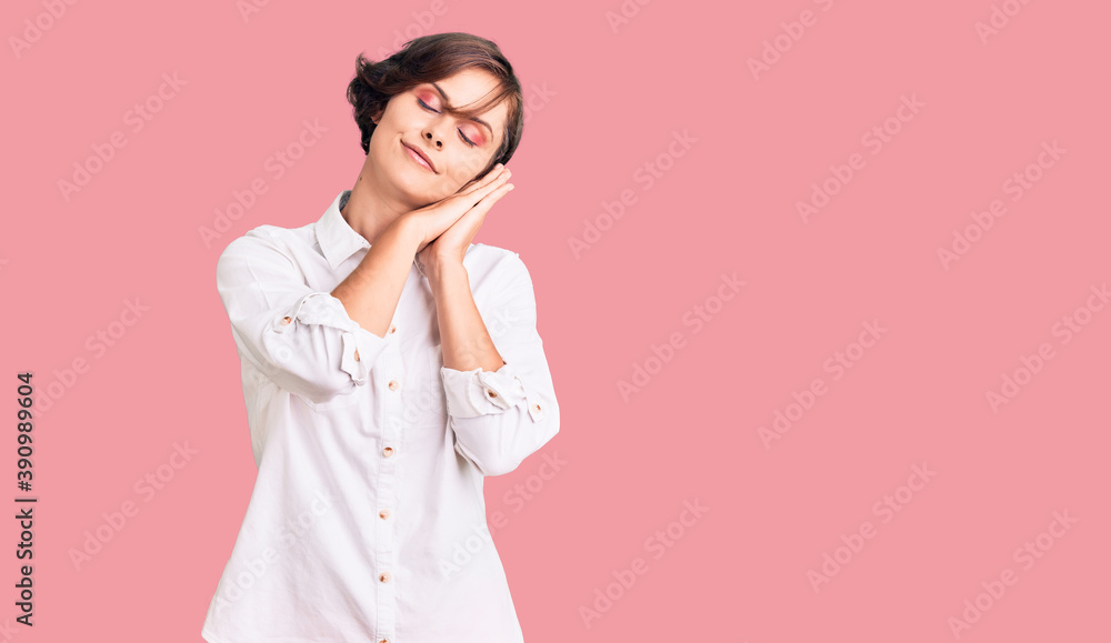 Beautiful young woman with short hair wearing elegant white shirt sleeping tired dreaming and posing with hands together while smiling with closed eyes. Beautiful young woman with short hair wearing elegant white shirt sleeping tired dreaming and posing with hands together while smiling with closed eyes.