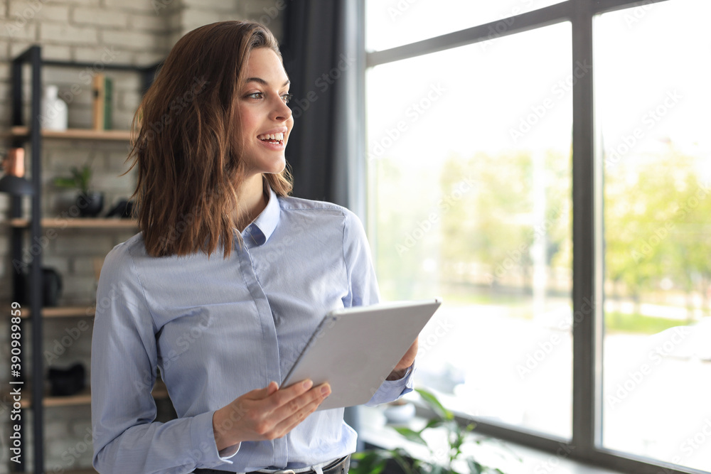 Attractive smiling woman working on a tablet in a home office. Attractive smiling woman working on a tablet in a home office.
