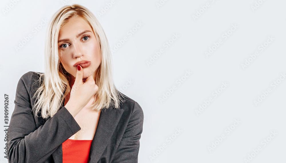 The woman thought about the choice and furrowed her eyebrows. Young beautiful blonde girl holds a hand to the face thinks and makes a decision. Place for advertising. What to choose The woman thought about the choice and furrowed her eyebrows. Young beautiful blonde girl holds a hand to the face thinks and makes a decision. Place for advertising. What to choose