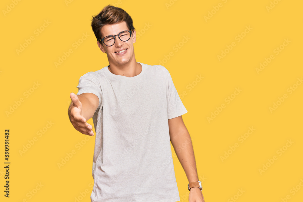 Handsome caucasian man wearing casual clothes and glasses smiling cheerful offering palm hand giving assistance and acceptance. Handsome caucasian man wearing casual clothes and glasses smiling cheerful offering palm hand giving assistance and acceptance.