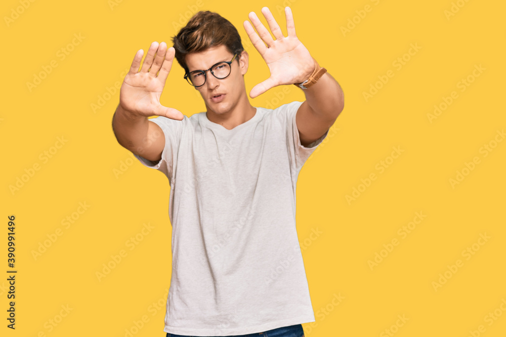Handsome caucasian man wearing casual clothes and glasses doing frame using hands palms and fingers, camera perspective Handsome caucasian man wearing casual clothes and glasses doing frame using hands palms and fingers, camera perspective
