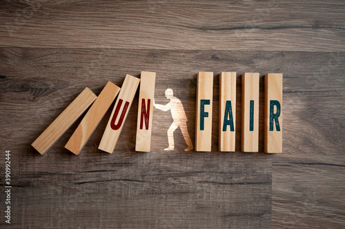 Pieces of wood with message fair and unfair on wooden background photo