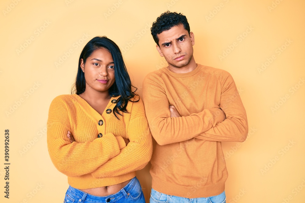 Fototapeta premium Beautiful latin young couple wearing casual clothes together skeptic and nervous, disapproving expression on face with crossed arms. negative person.