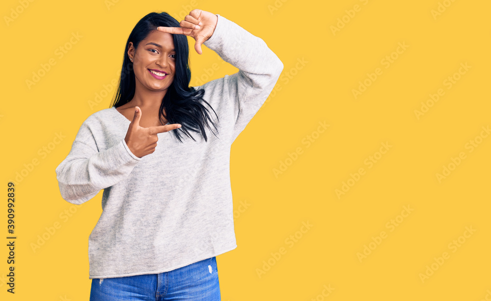 Hispanic woman with long hair wearing casual clothes smiling making frame with hands and fingers with happy face. creativity and photography concept. Hispanic woman with long hair wearing casual clothes smiling making frame with hands and fingers with happy face. creativity and photography concept.