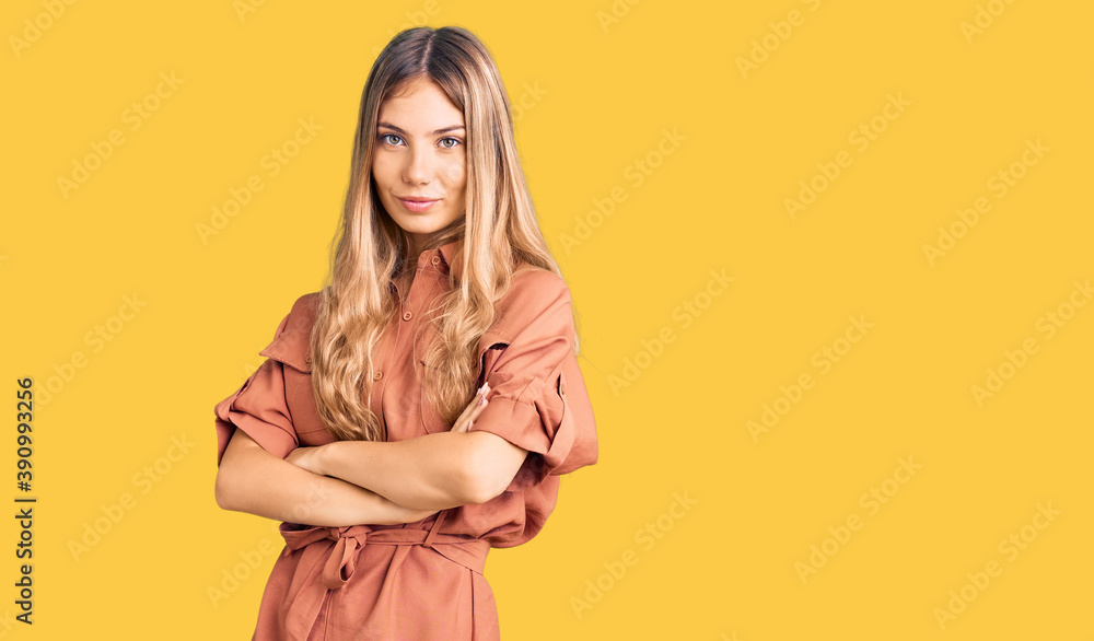Obraz premium Beautiful caucasian woman with blonde hair wearing summer jumpsuit looking to the side with arms crossed convinced and confident