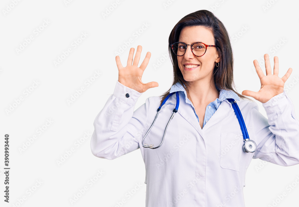 Young beautiful woman wearing doctor stethoscope and glasses showing and pointing up with fingers number ten while smiling confident and happy. Young beautiful woman wearing doctor stethoscope and glasses showing and pointing up with fingers number ten while smiling confident and happy.