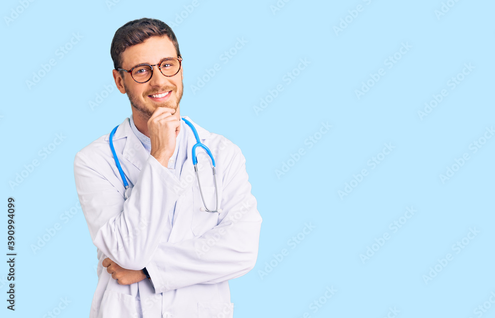 Handsome young man with bear wearing doctor uniform looking confident at the camera with smile with crossed arms and hand raised on chin. thinking positive. Handsome young man with bear wearing doctor uniform looking confident at the camera with smile with crossed arms and hand raised on chin. thinking positive.