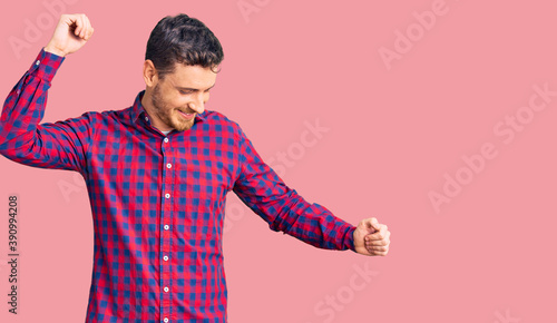Handsome young man with bear wearing casual shirt dancing happy and cheerful, smiling moving casual and confident listening to music