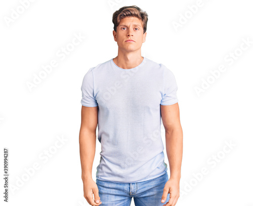 Young handsome man wearing casual clothes with serious expression on face. simple and natural looking at the camera.