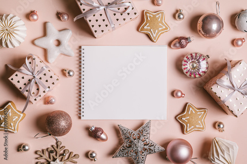 Christmas composition. Frame with gingerbread, gifts, Christmas decorations and an empty sheet for text on pastel pink background.