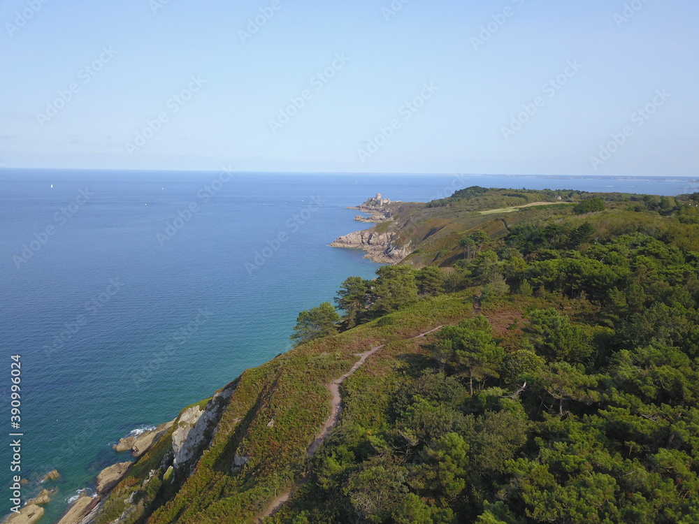 drone photo, France, Brittany, Fort La Latte with coastline, green trees and grass, cliffs and blue sea and sky