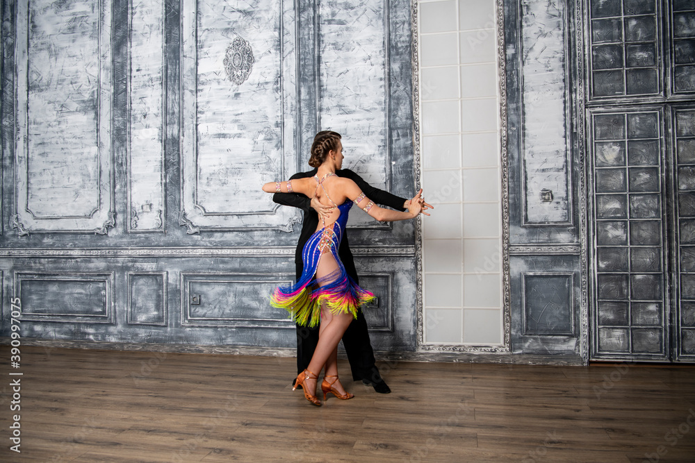 Obraz premium beautiful couple with dance costumes dancing latin dances in the hall