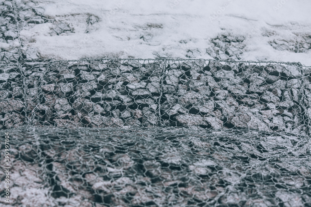 Obraz premium Reinforcing mesh on stones. Strengthening along the road