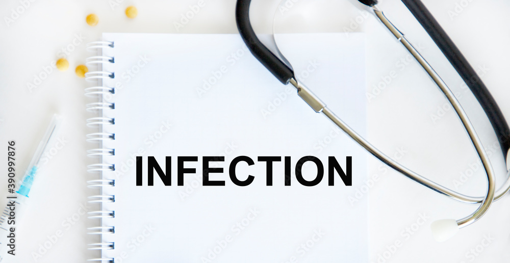 In the notebook text INFECTION, around is a stethoscope, a syringe, tablets. In the notebook text INFECTION, around is a stethoscope, a syringe, tablets.