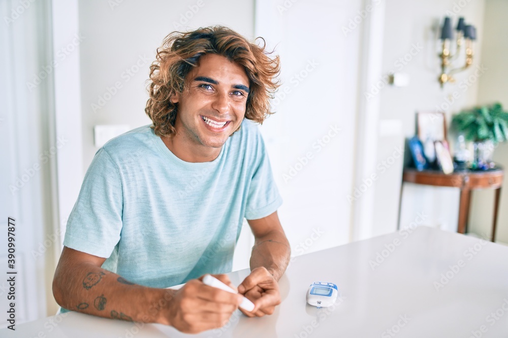 Young hispanic diabetic man smiling happy measuring glucose level at home Young hispanic diabetic man smiling happy measuring glucose level at home