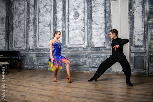 beautiful couple with dance costumes dancing latin dances in the hall © константин константи