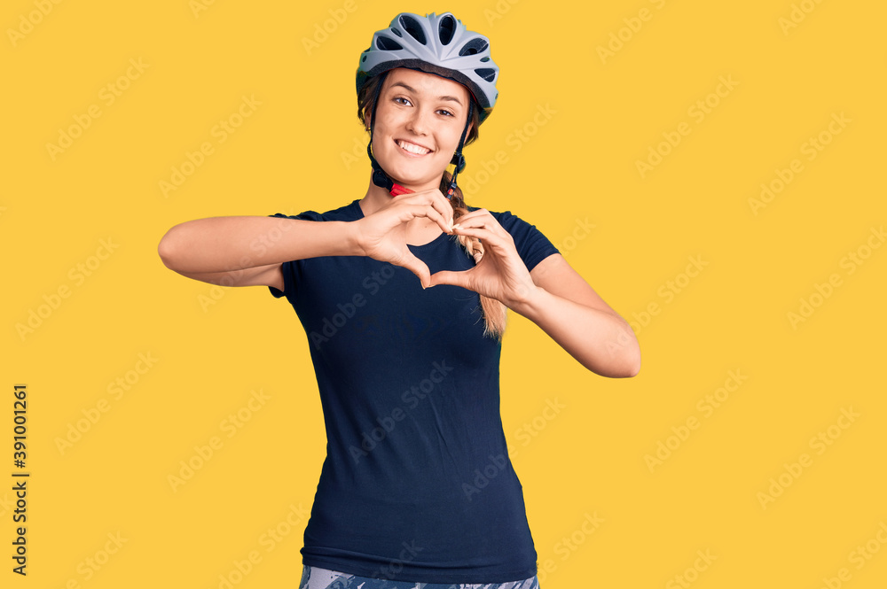 Beautiful caucasian woman wearing bike helmet smiling in love doing heart symbol shape with hands. romantic concept. Beautiful caucasian woman wearing bike helmet smiling in love doing heart symbol shape with hands. romantic concept.