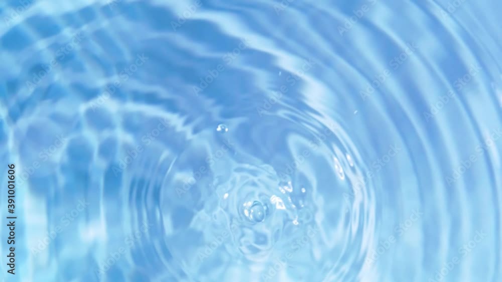 Top view slow motion of drop falling into the water surface and diverging circles on white background Top view slow motion of drop falling into the water surface and diverging circles on white background
