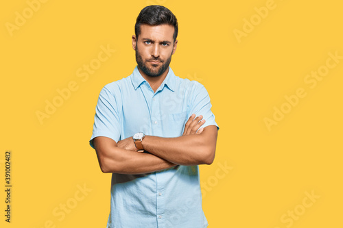 Handsome hispanic man wearing casual clothes skeptic and nervous, disapproving expression on face with crossed arms. negative person.