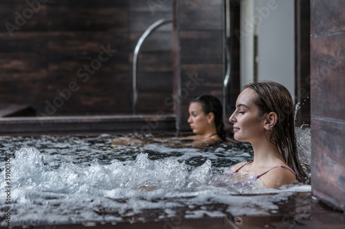 Woman relaxing in hot tub in spa center
