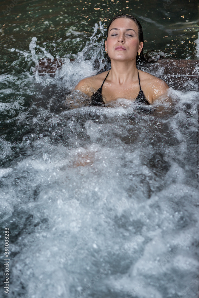 Woman relaxing in hot tub with closed eyes