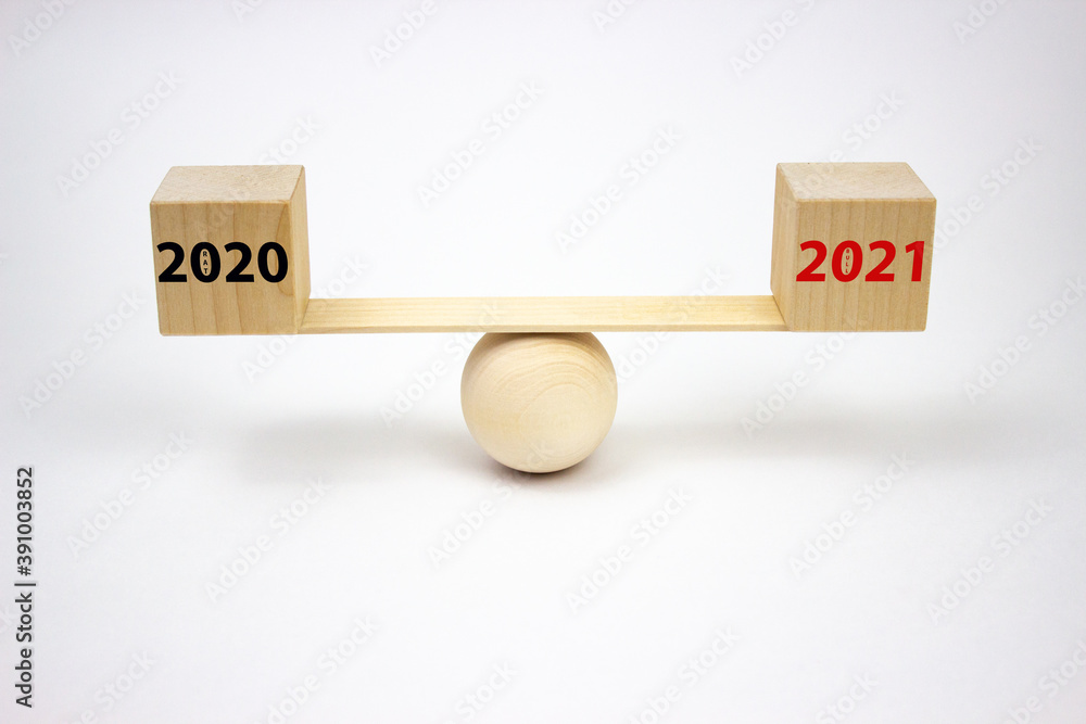 The inscription on the cubes of wooden scales 2020 and 2021 with the words rat and bull, in black and red. The concept of planning the future and analyzing the past. The inscription on the cubes of wooden scales 2020 and 2021 with the words rat and bull, in black and red. The concept of planning the future and analyzing the past.