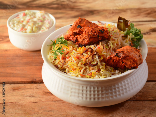Chicken Tikka Biryani made of Basmati rice cooked with masala spices, served with yogurt, selective focus