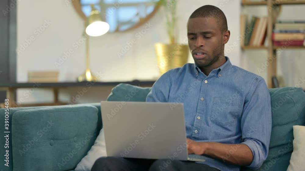 Young African Man with Laptop Coughing on Sofa Young African Man with Laptop Coughing on Sofa