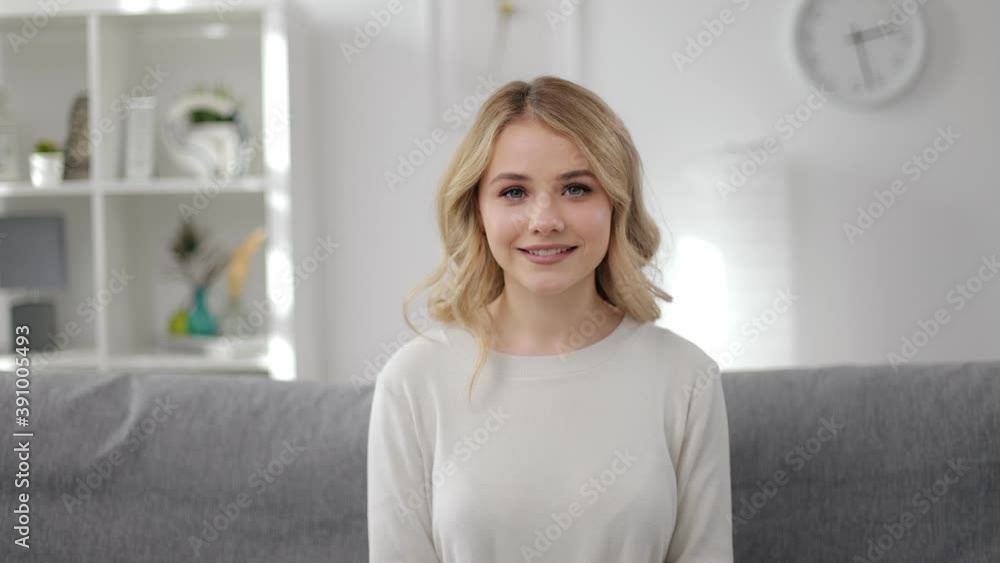 Portrait of young woman with blond hair sitting on couch, smiling. Pretty lady spending leisure time at home. Domestic outfit. Portrait of young woman with blond hair sitting on couch, smiling. Pretty lady spending leisure time at home. Domestic outfit.