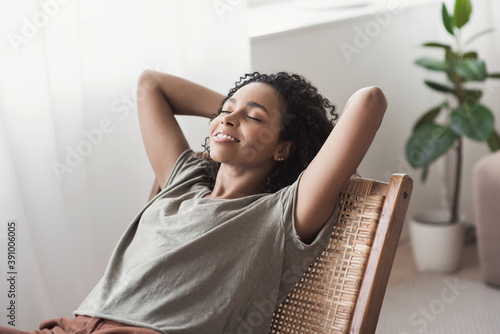 Young woman relaxing at home.  African american girl resting in her room. Enjoy life, rest, relaxation, wellbeing, lifestyle, people, recreation concept photo