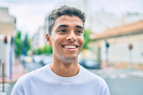 Young latin man smiling happy walking at the city. © Krakenimages.com