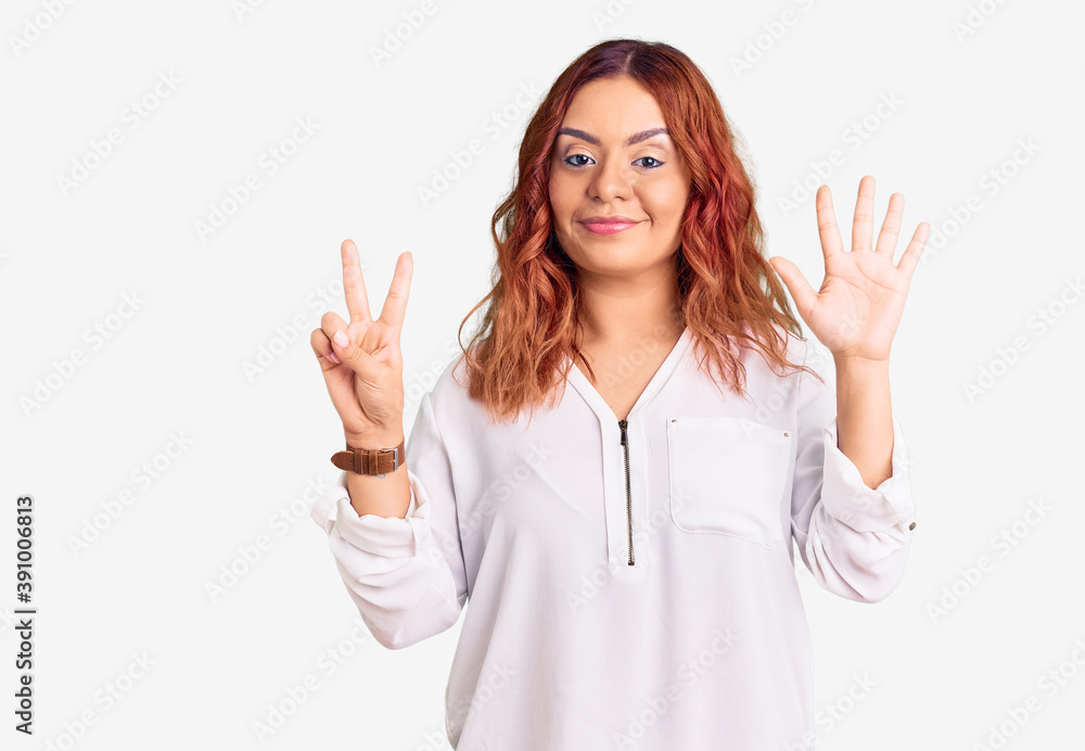 Young latin woman wearing casual clothes showing and pointing up with fingers number seven while smiling confident and happy. Young latin woman wearing casual clothes showing and pointing up with fingers number seven while smiling confident and happy.