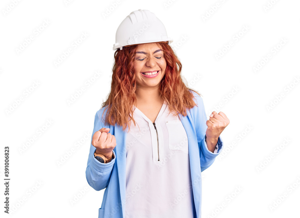 Young latin woman wearing architect hardhat excited for success with arms raised and eyes closed celebrating victory smiling. winner concept.