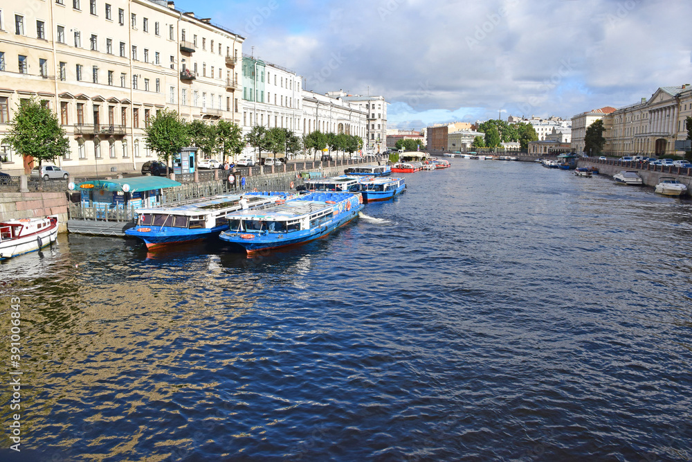 Fototapeta premium View of the Fontanka river and piers with pleasure boats from the Anichkov bridge. Russia, Saint Petersburg, September 2020