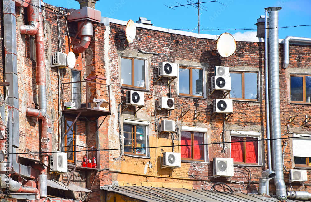 Wall of a residential building with air conditioning and TV antennas. View from the courtyard. Russia, Saint Petersburg, September 2020