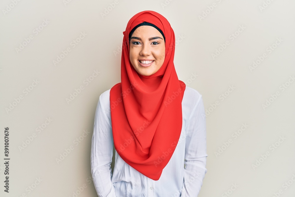 Young beautiful hispanic girl wearing traditional islamic hijab scarf with a happy and cool smile on face. lucky person. Young beautiful hispanic girl wearing traditional islamic hijab scarf with a happy and cool smile on face. lucky person.