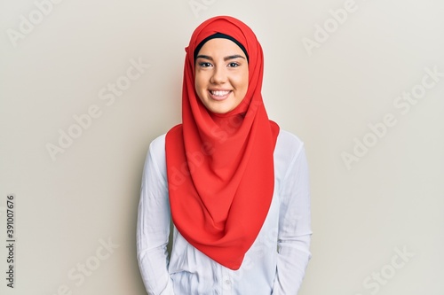 Young beautiful hispanic girl wearing traditional islamic hijab scarf with a happy and cool smile on face. lucky person. © Krakenimages.com