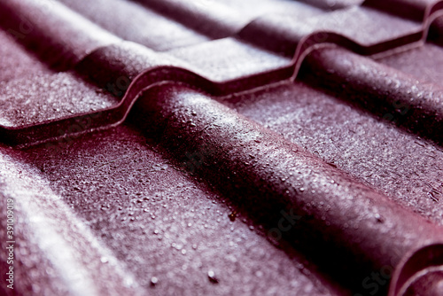 Red metallic roof tiles background with drops of water.